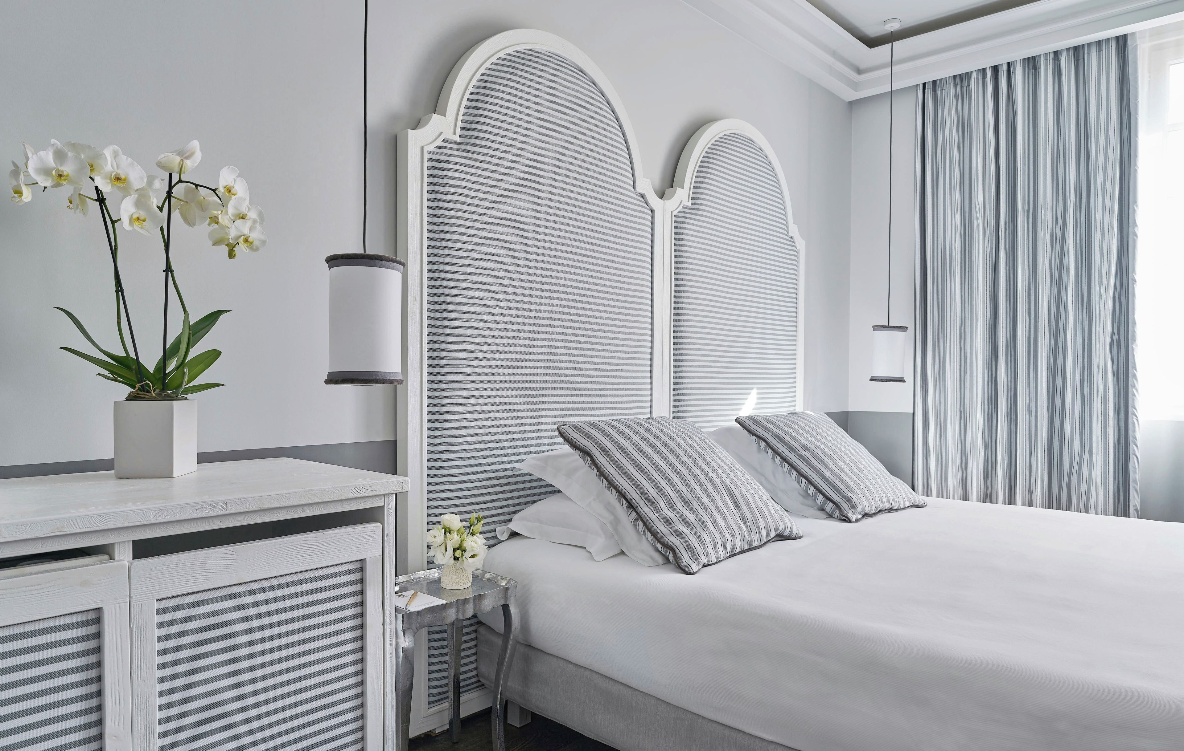 A modern bedroom with a large bed, a bedside table, and a nightstand.