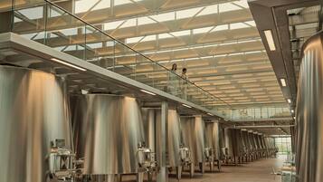Un interior moderno de estilo industrial con tanques de acero inoxidable y un techo alto con tragaluces.