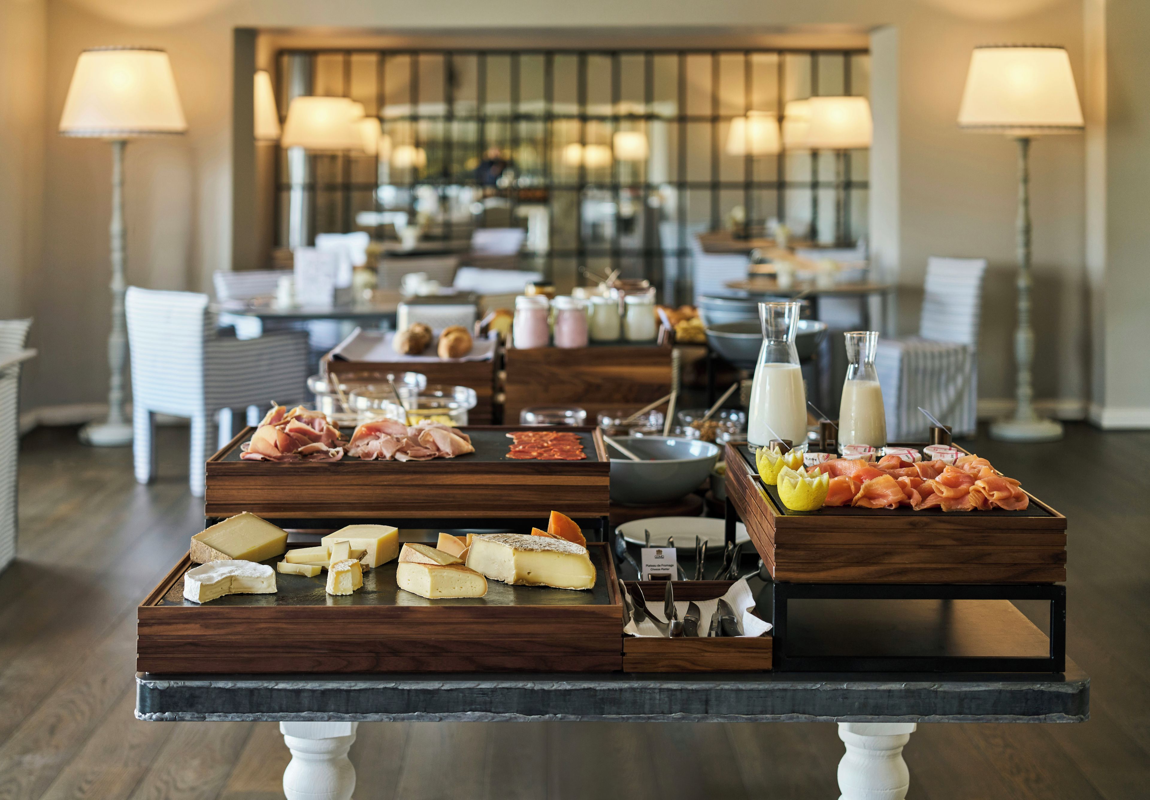 Una mesa de buffet con diversos quesos, embutidos y condimentos.