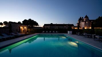 Alberca al aire libre, sombrillas en la alberca y camastros