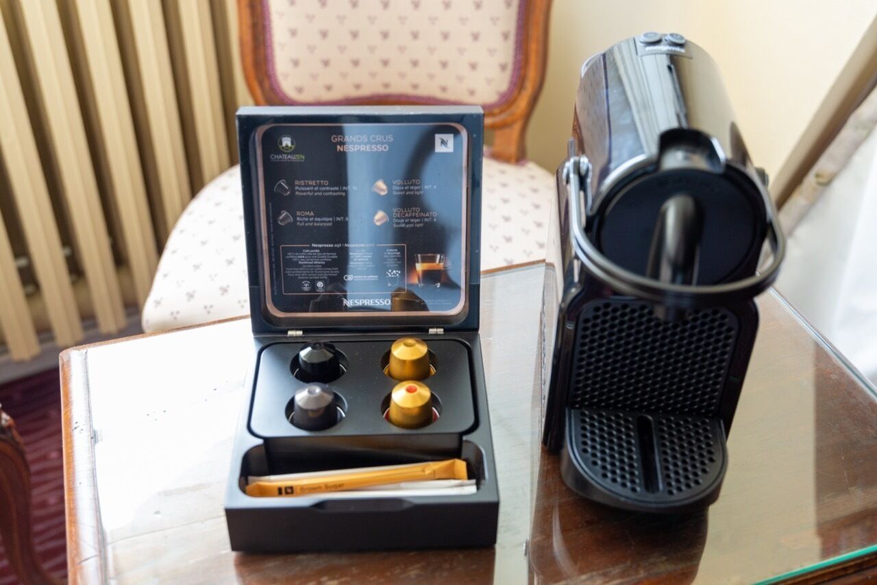 Una máquina Nespresso y su caja sobre una mesa.