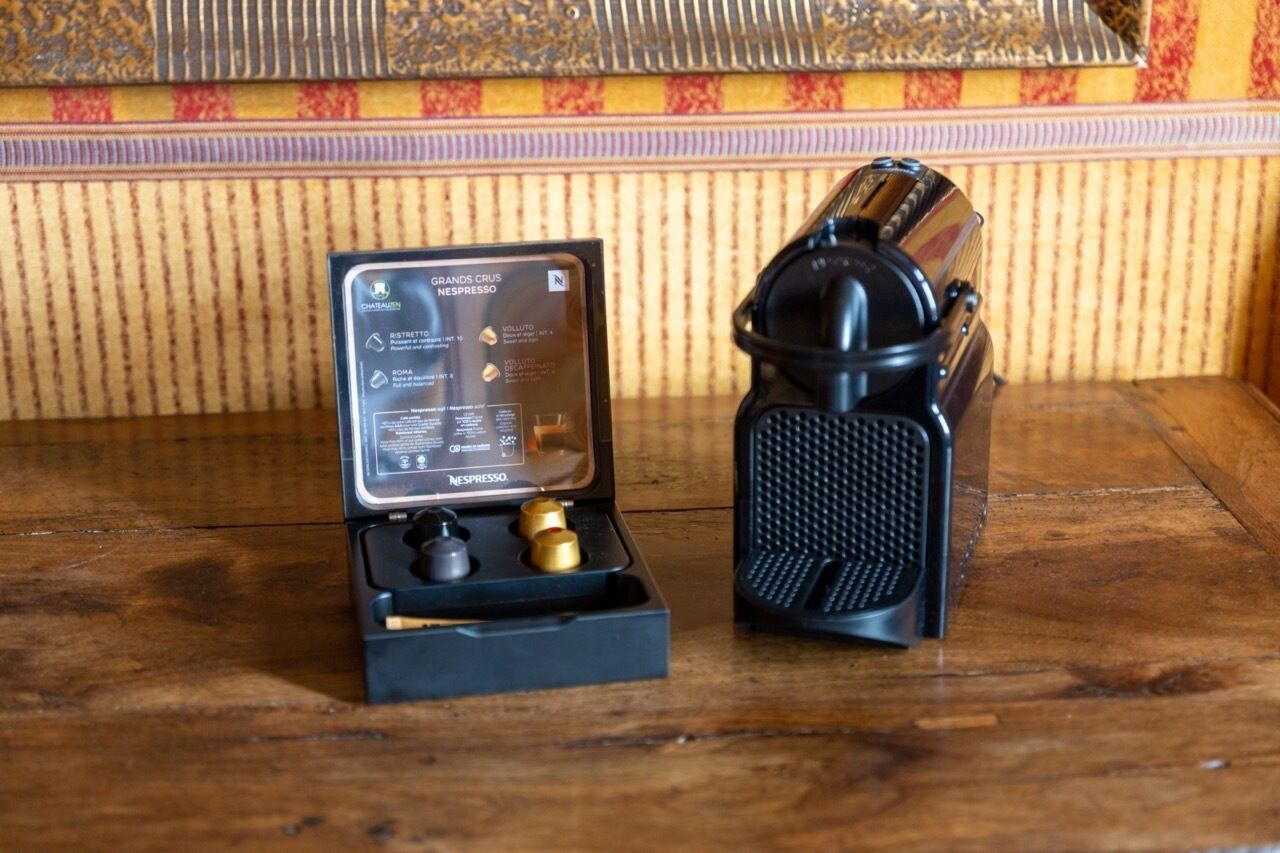 Une machine Nespresso et ses différents éléments, posés sur une surface en bois.
