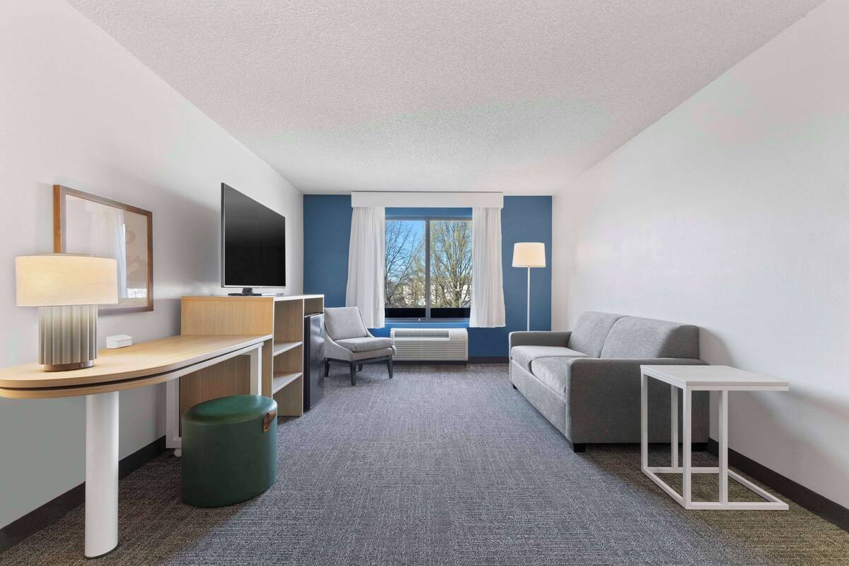 Une chambre d’hôtel équipée d’un bureau, d’une chaise, d’un canapé et d’une petite table.