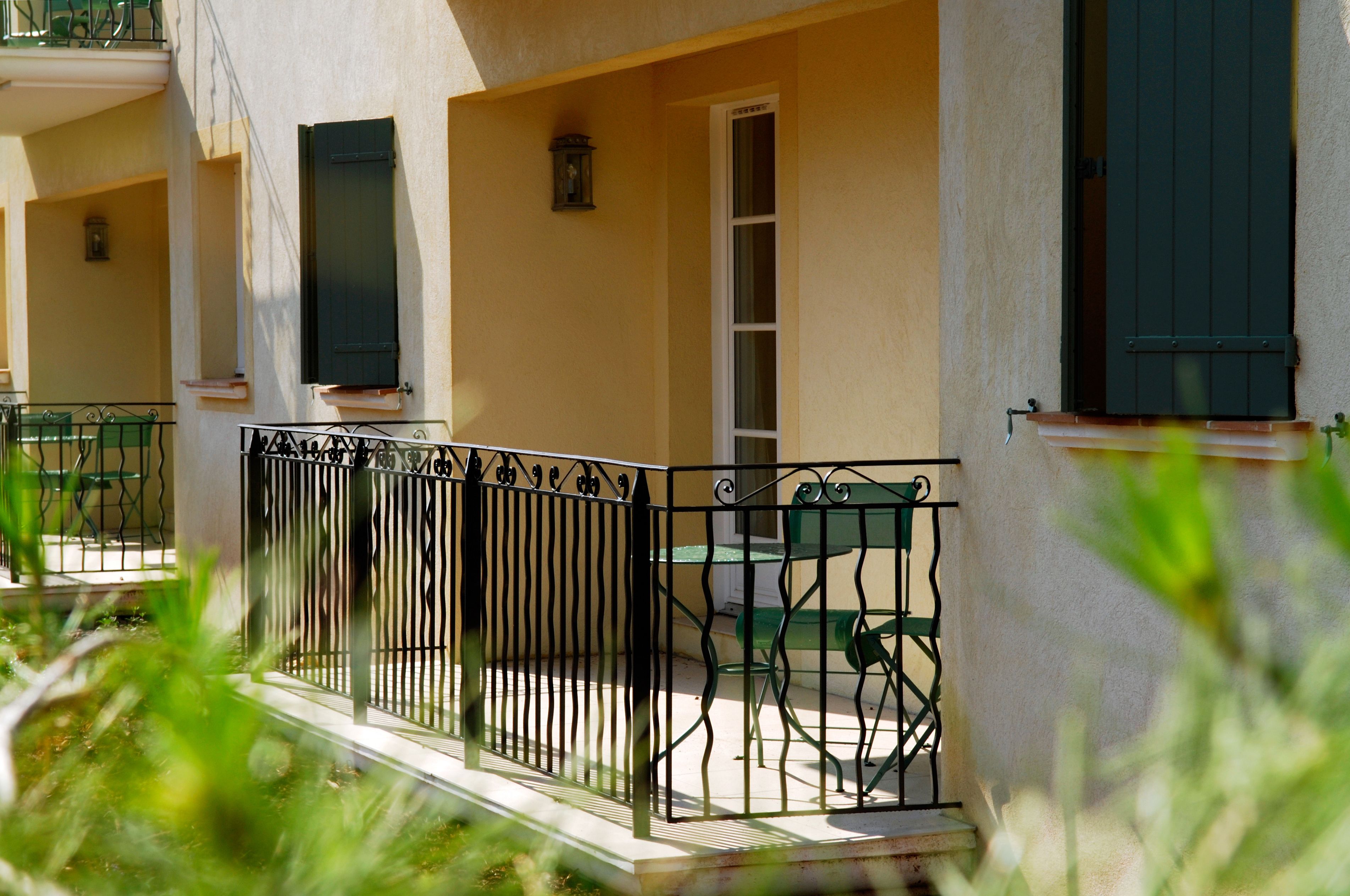 A building with a balcony, a door, and a window.