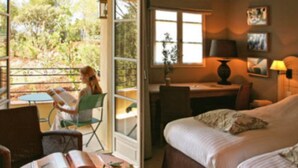 A room with a bed, a desk, and a chair. There is a window with a view of trees outside. - Domaine de Saint Endréol Golf & Spa Resort**** (La Motte)