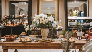 Een buffet met diverse gerechten en een grote vaas witte bloemen.