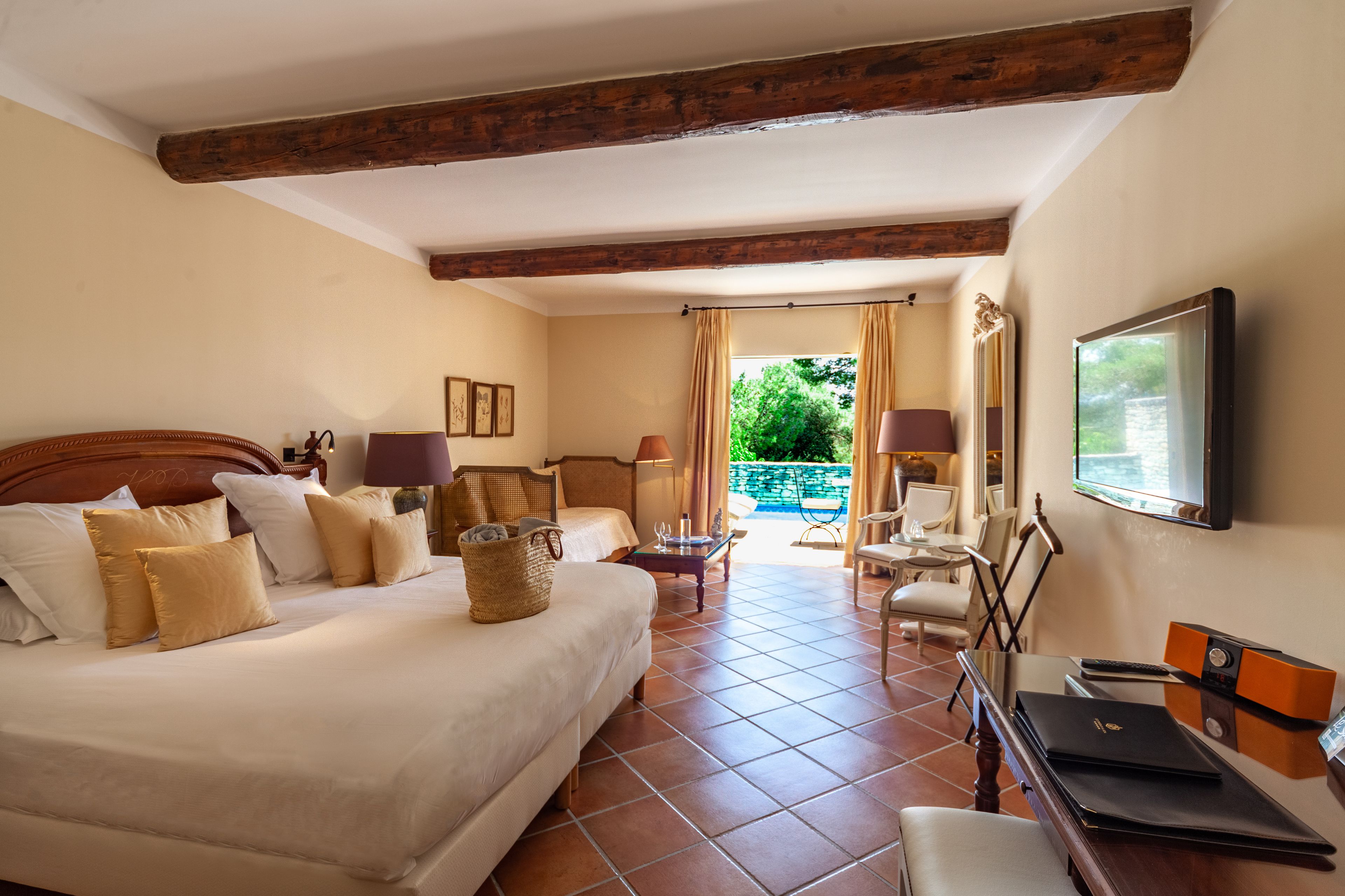 Une chambre d’hôtel avec un grand lit, un bureau avec un ordinateur portable, une chaise et un téléviseur fixé au mur.