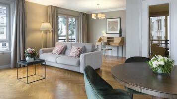 Uma sala de estar moderna com um sofá, uma mesa de jantar e uma escrivaninha com abajur.