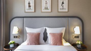 A hotel room with a bed, two bedside tables with lamps, and three framed pictures on the wall.