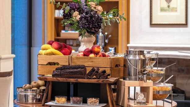 Un bufé de desayuno con frutas, bollería y bebidas.