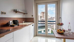 Una cocina moderna con encimera de madera, cafetera y frutero.