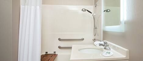 A bathroom with a shower, a toilet, and a sink.
