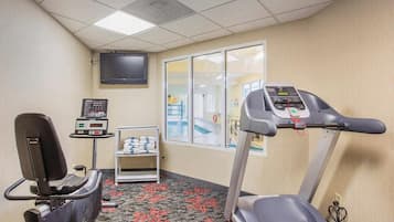 Un gimnasio con cinta de correr, bicicleta estática y báscula.
