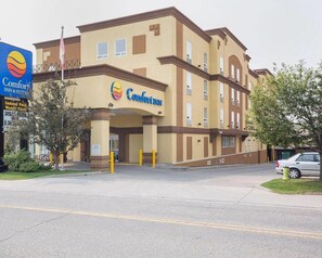 A Comfort Inn hotel with a two-story structure, a prominent sign, and a parking area. - Comfort Inn & Suites Calgary - University (Calgary)