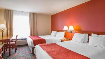 Une chambre d’hôtel avec deux lits, un bureau et une chaise.