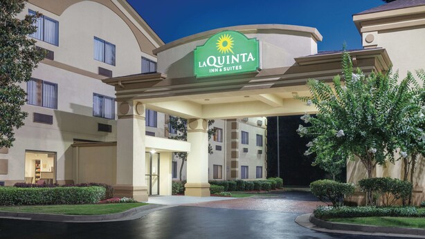 A hotel entrance with a sign reading "La Quinta Inn & Suites." - La Quinta Inn & Suites by Wyndham Jackson Airport/Pearl (Pearl)