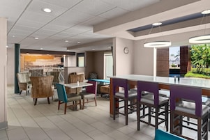 Un comedor moderno con barra, asientos y vistas al exterior.