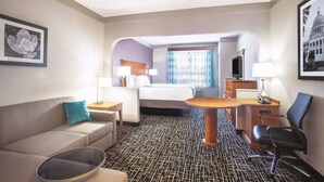 A hotel room with a bed, a sofa, a desk, and a chair. - La Quinta Inn & Suites by Wyndham Jackson Airport/Pearl (Pearl)