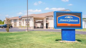 Une enseigne de l’hôtel Howard Johnson, offrant une vue dégagée sur l’entrée de l’établissement et le parking.