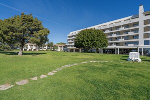 Un hotel con diseño moderno, césped bien cuidado y cielo despejado.