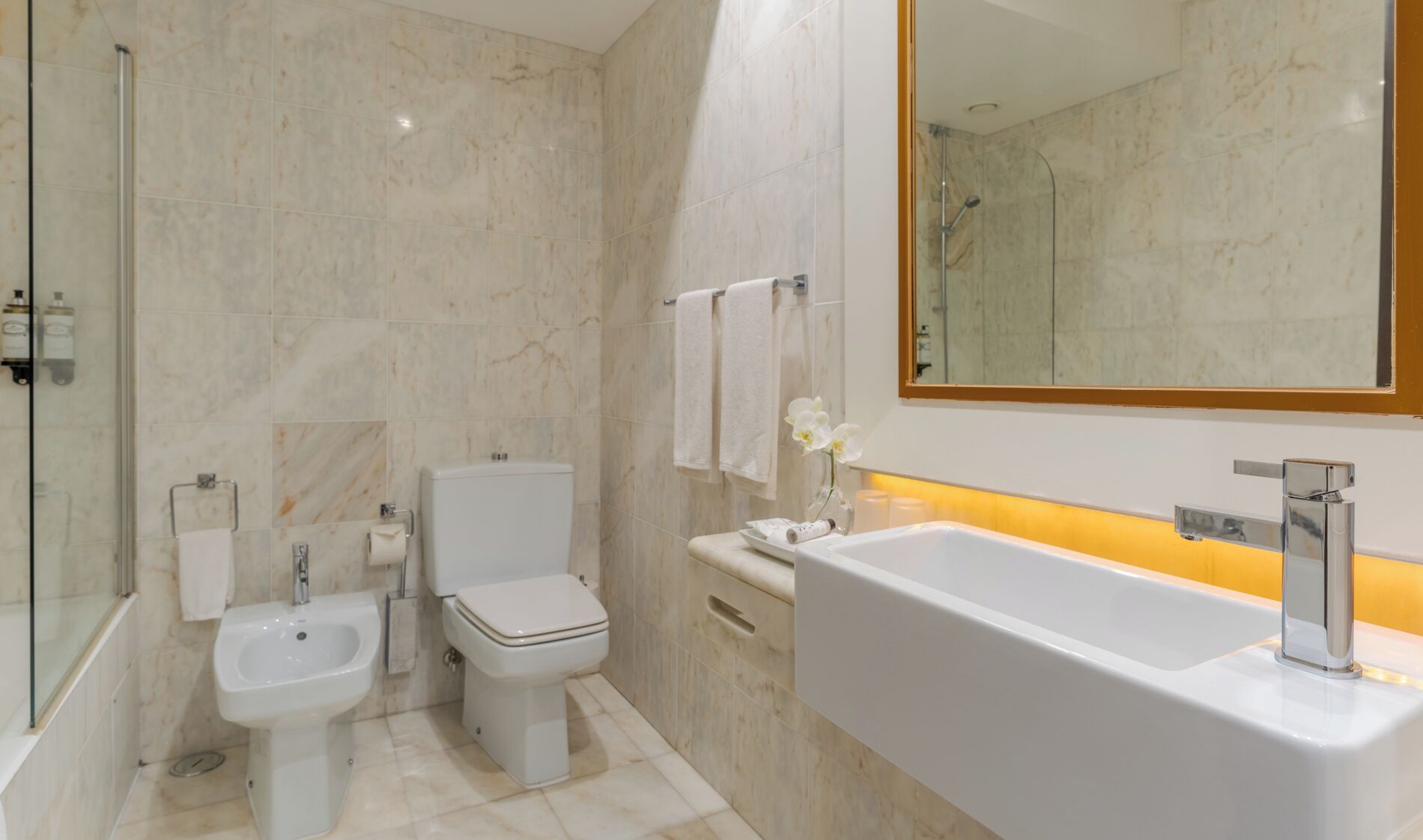 Ein modernes Badezimmer mit Duschkabine aus Glas, einem Bidet, einer Toilette und einer großen Badewanne.