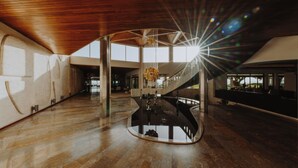 Un ampio atrio con una scala centrale, ampie finestre e un moderno lampadario.
