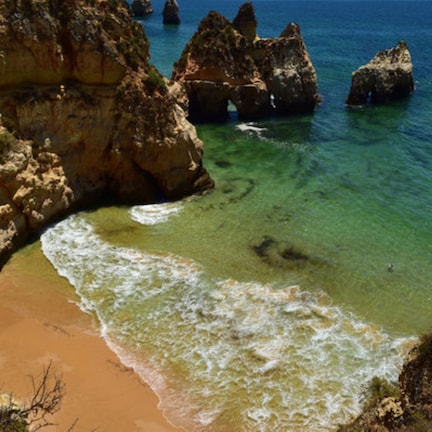 A coastal landscape with rocky cliffs and clear turquoise waters.