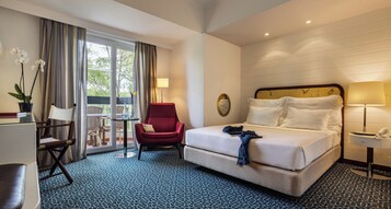 Suite, Garden View | Minibar, in-room safe, desk, blackout drapes