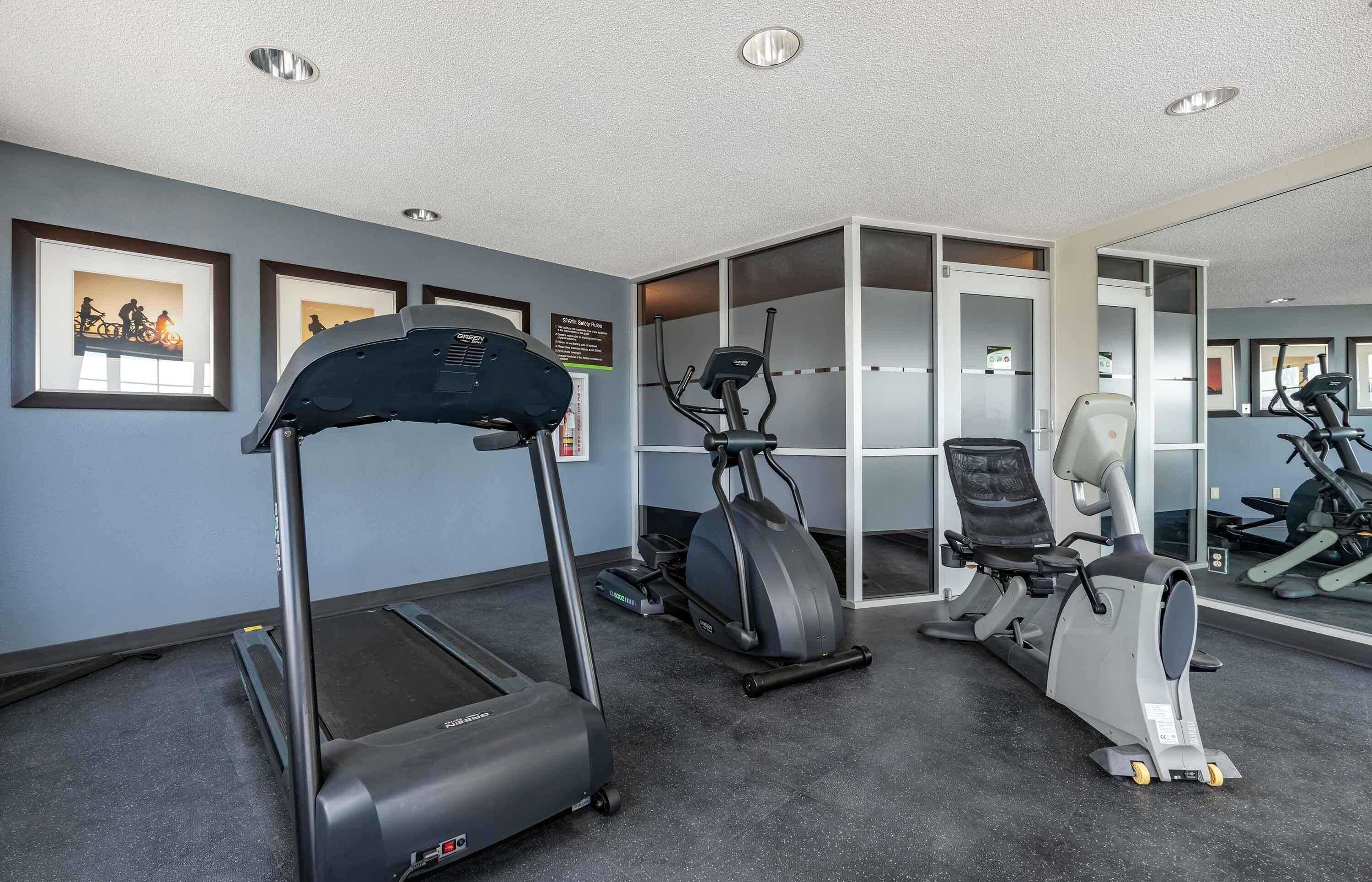 A gym with treadmills, an elliptical, and a stationary bike.