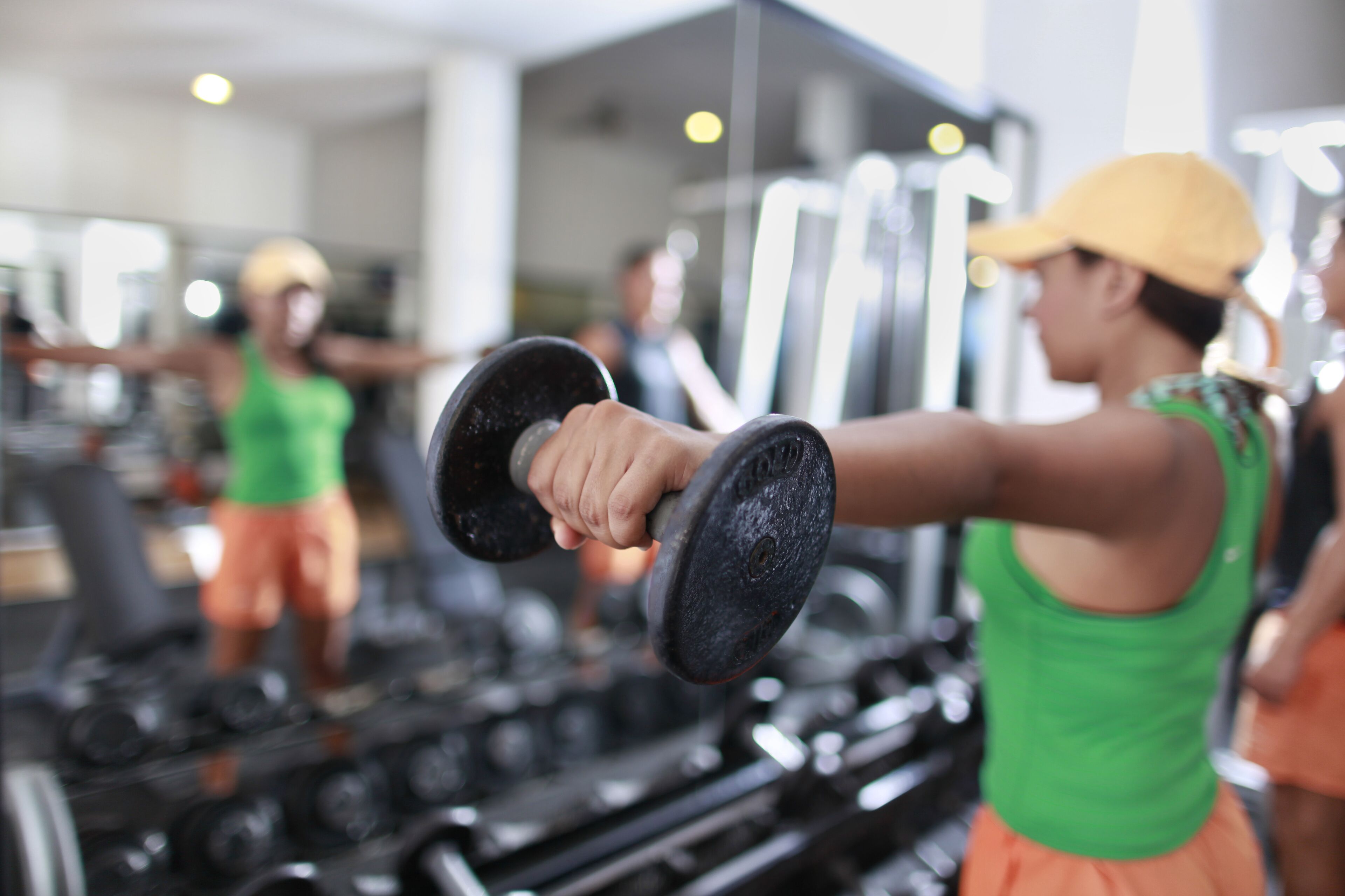 Une salle de sport équipée de matériel d’exercice et où des personnes s’entraînent.