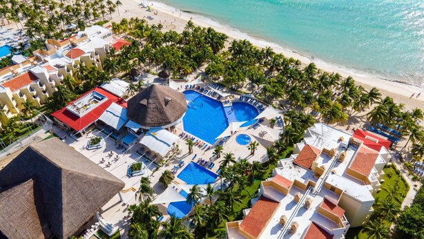 An aerial view of a resort with multiple swimming pools, beach access, and palm trees. - Viva Maya by Wyndham, A Trademark Resort (Playa del Carmen)