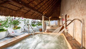A hot tub with a thatched roof, surrounded by lounge chairs and potted plants. - Viva Maya by Wyndham, A Trademark Resort (Playa del Carmen)