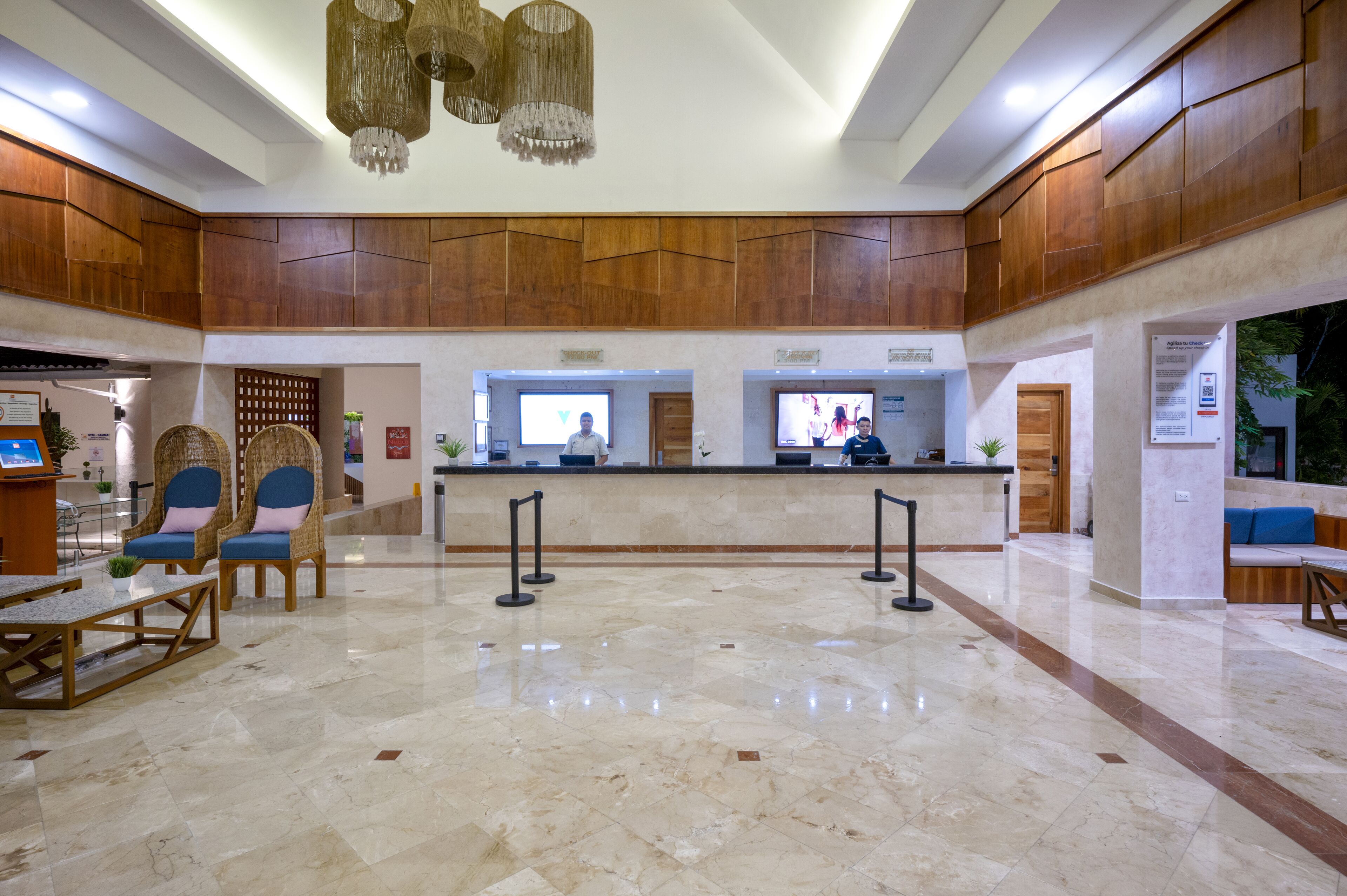 A spacious lobby with a reception desk, seating area, and a chandelier.