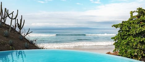 En la playa, sillas reclinables de playa, sombrillas, toallas de playa