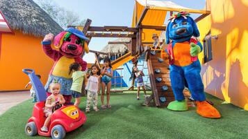 A children's play area with a slide, climbing structures, and a mascot.