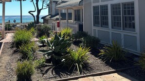 A building with a white exterior, large windows, and a tiled roof. - FogCatcher Inn (Cambria)
