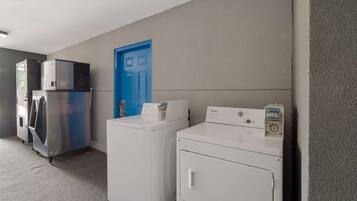 A laundry area with stacked dryers and a blue door.