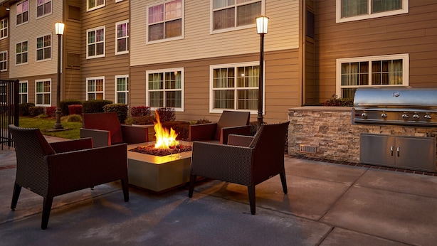 An outdoor patio with a fire feature, wicker furniture, and a barbecue grill. - Residence Inn Eugene Springfield (Eugene)