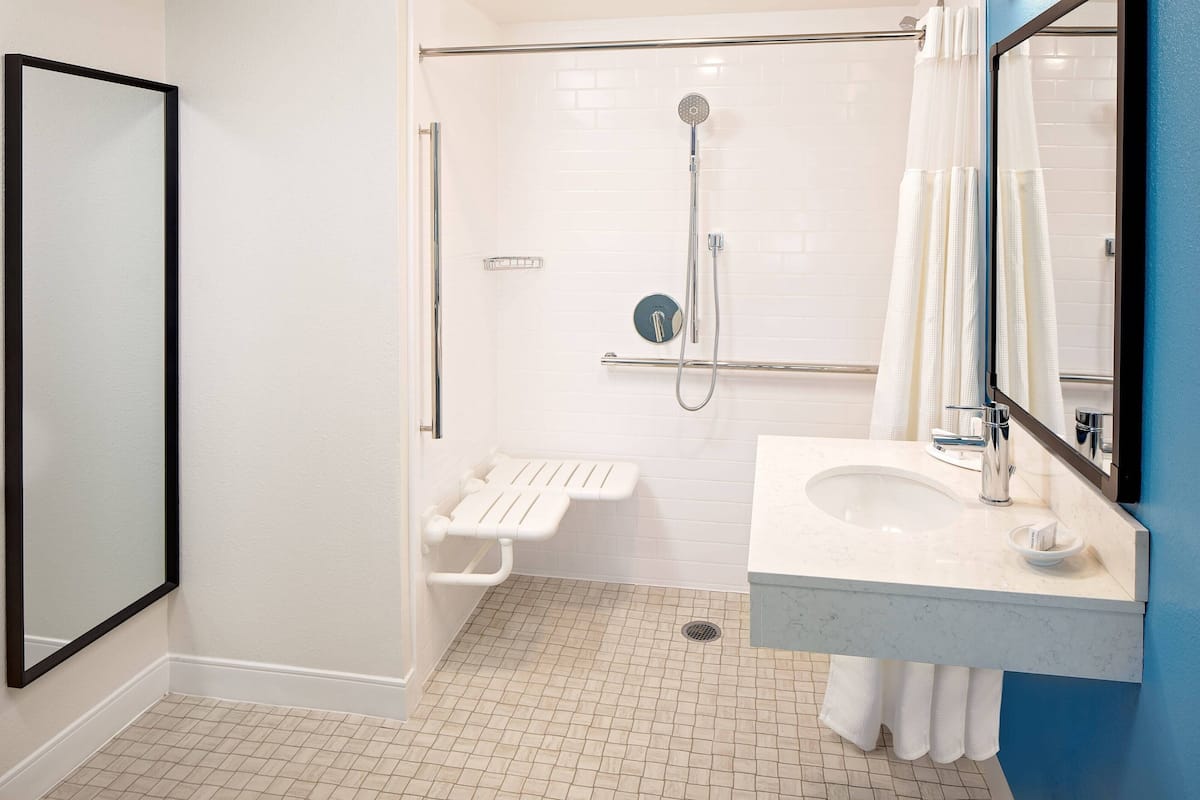 A modern bathroom with a shower, toilet, and sink.