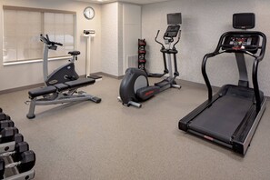 A gym with cardio machines, dumbbells, and a clock on the wall. - Residence Inn by Marriott Tysons (Vienna)