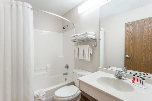 A modern bathroom with a bathtub, toilet, and sink.