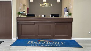 A reception area with a Baymont Inn & Suites sign, a reception desk, and a blue doormat. - Baymont by Wyndham Anderson (Anderson)