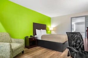 A hotel room with a bed, a chair, a nightstand, and a lamp. - Quality Inn Bessemer I-20 exit 108 (Bessemer)