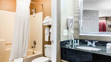 A bathroom with a bathtub, toilet, and sink.