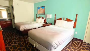 A hotel room with two beds, a bathroom, and a patterned carpet.