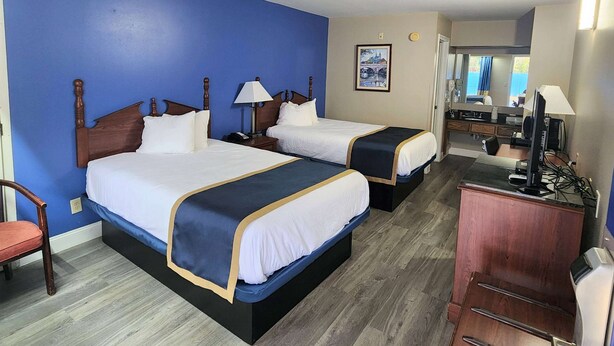 A hotel room with two beds, a desk, a chair, and a mirror. - Baymont by Wyndham Eufaula (Eufaula)