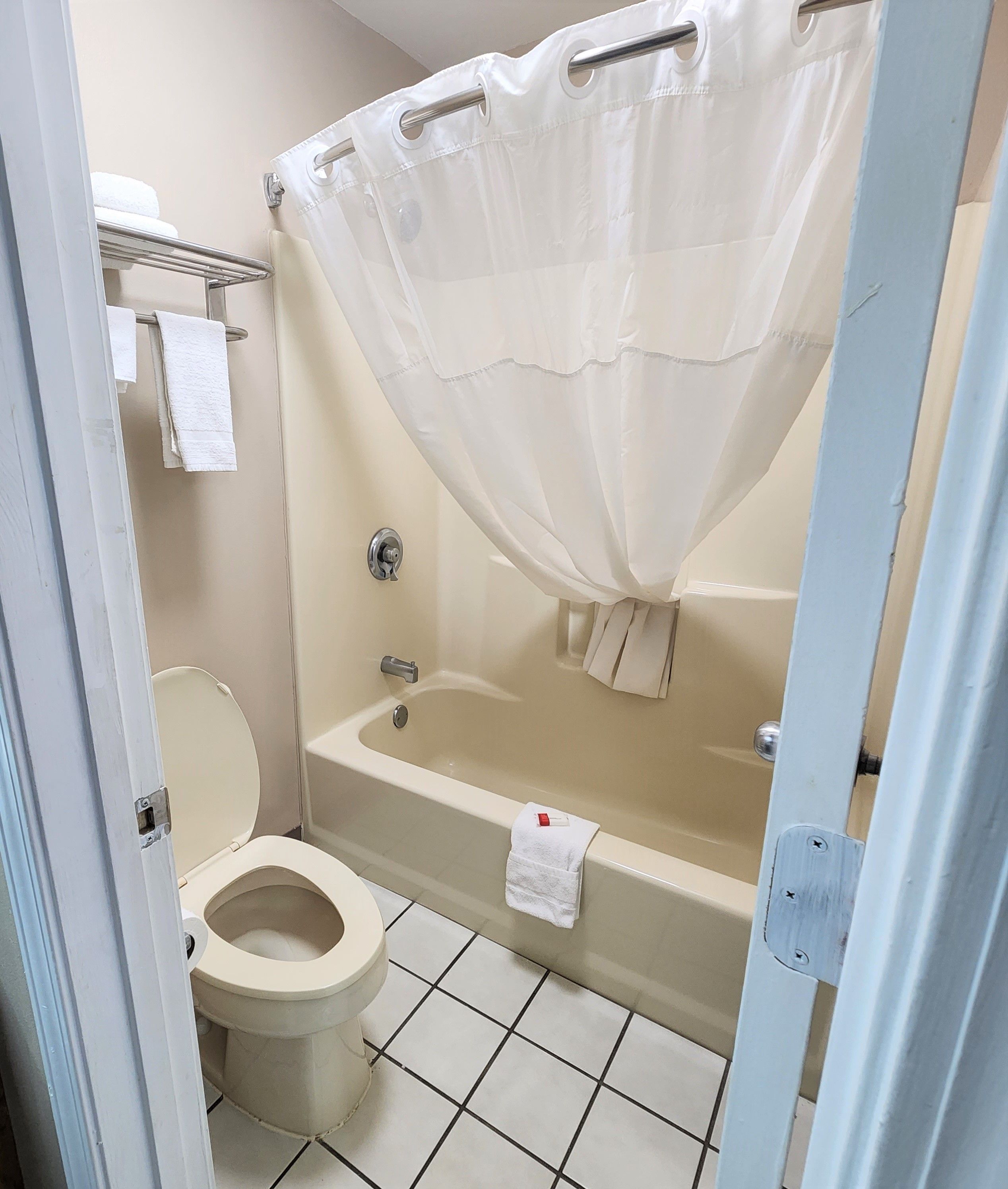 A bathroom with a toilet, bathtub, and shower curtain.