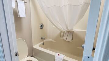 A bathroom with a toilet, bathtub, and shower curtain.