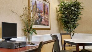 A conference room with a large table, chairs, a computer, and a painting on the wall. - Baymont by Wyndham Eufaula (Eufaula)
