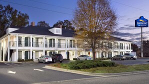 A two-story motel with a white facade and a dark roof, featuring a sign for Baymont Inn & Suites. - Baymont by Wyndham Eufaula (Eufaula)